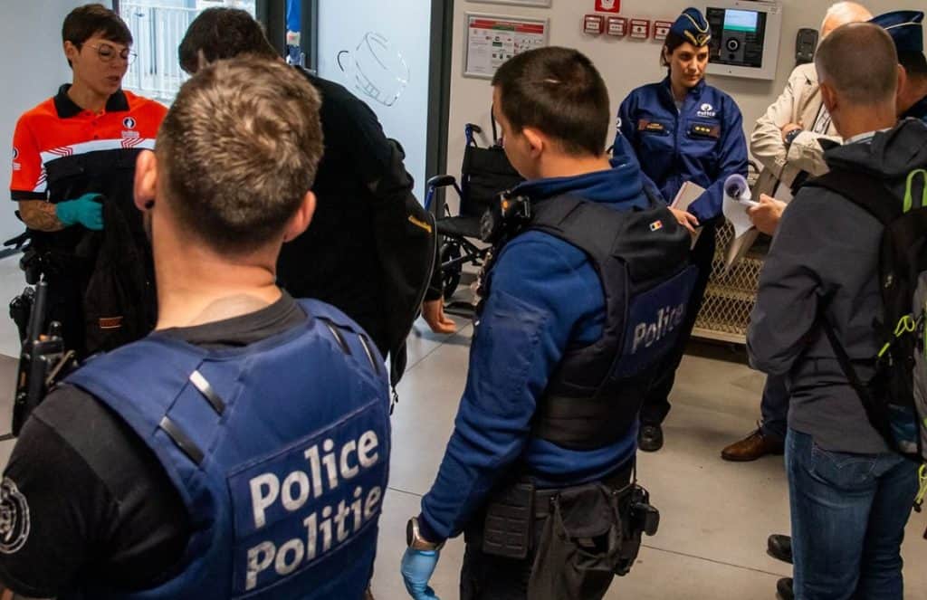 Politieagenten en officieren bespreken strategie in politiebureau.