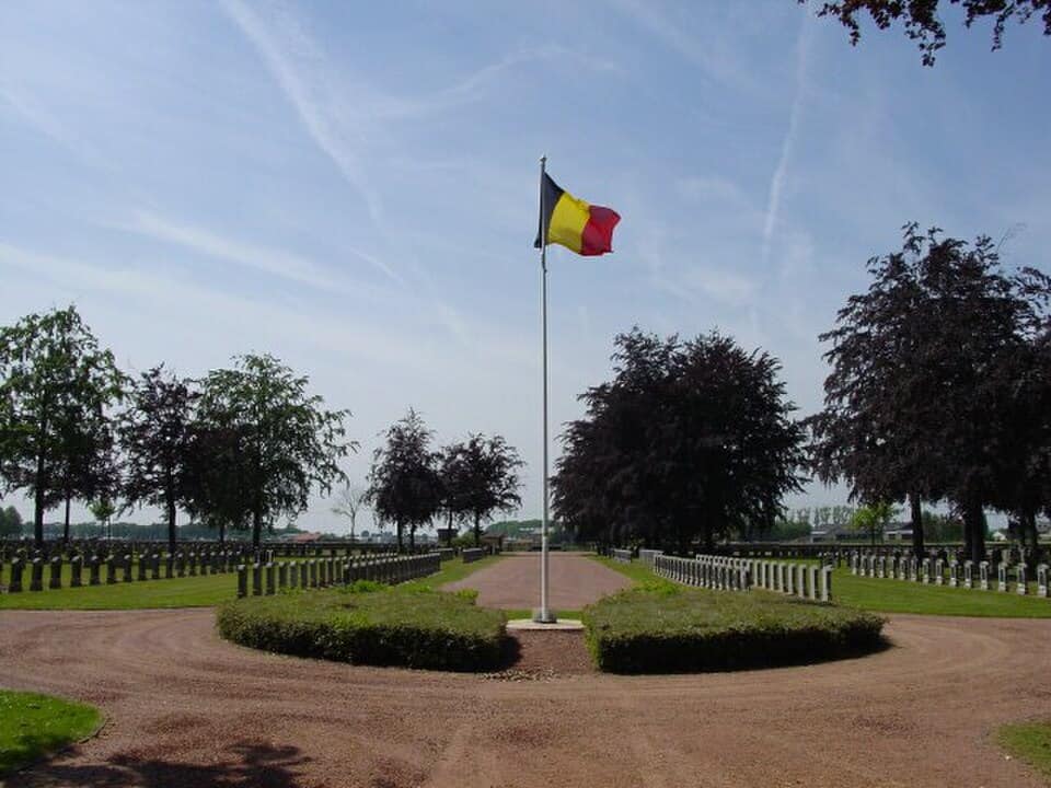 Belgische vlag op militaire begraafplaats Houthulst in de zon.