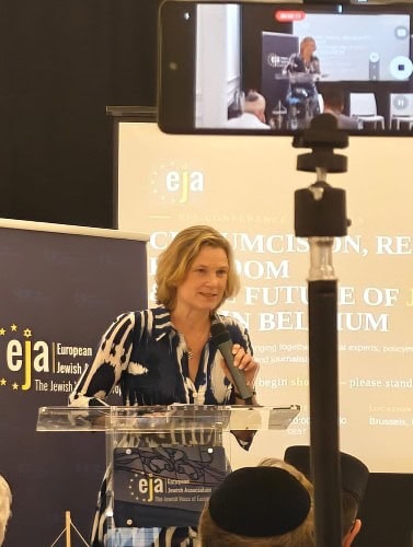 Vrouw spreekt tijdens conferentie over antisemitisme en Joods leven in Europa.