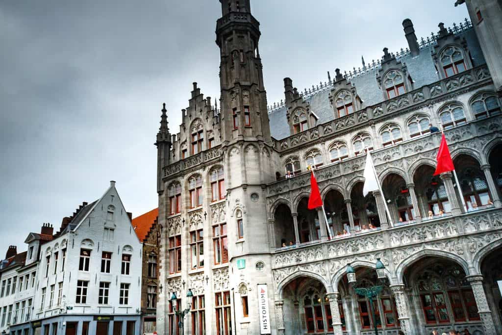Gothisch gebouw in Brussel met rode vlaggen en torentjes.