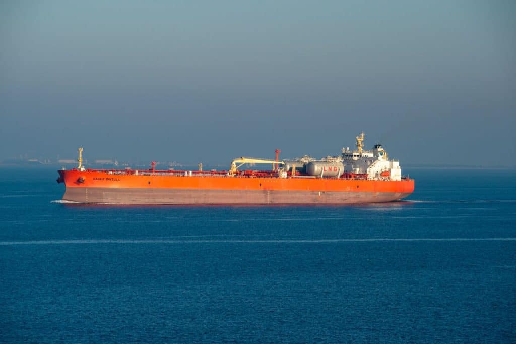 Olietanker vaart door kalme wateren onder een heldere hemel.